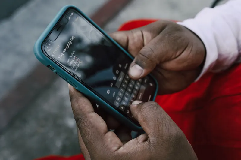 Person teilt eine Weihnachtswunschliste per Smartphone mit der Familie