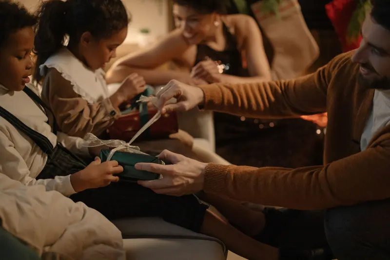 Familie teilt Geschenke und feiert gemeinsam zu Hause