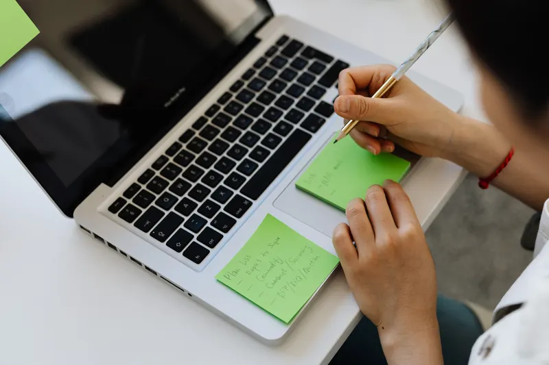 Person notiert Geburtstagswünsche am Laptop Person notiert Geburtstagswünsche am Laptop