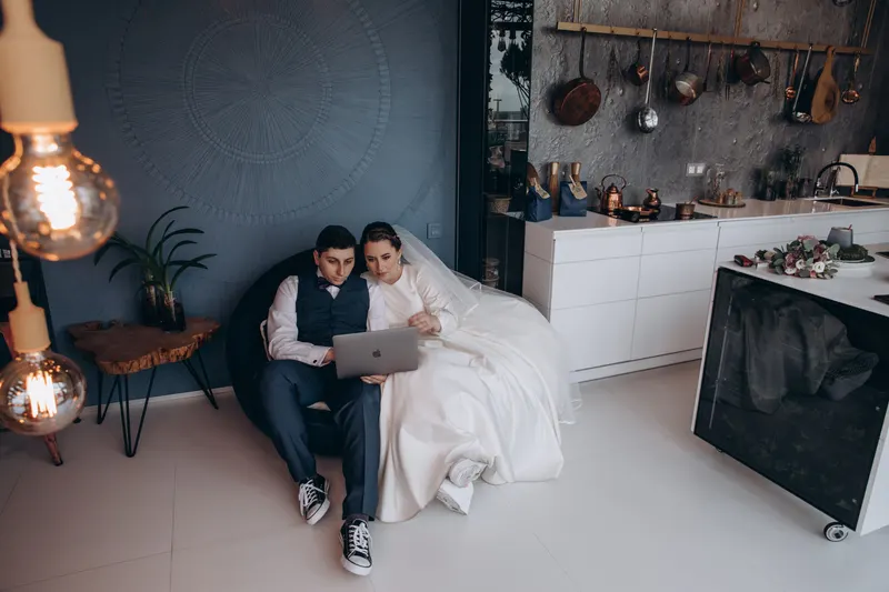 Paar stellt gemeinsam die Hochzeitswunschliste am Laptop zusammen