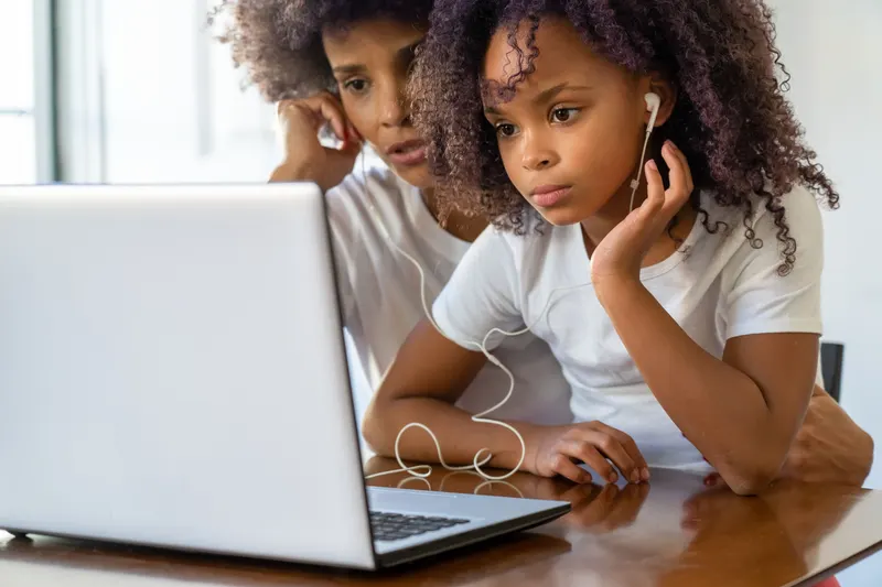Kind und Eltern stellen gemeinsam eine Wunschliste am Laptop zusammen Kind und Eltern stellen gemeinsam eine Wunschliste am Laptop zusammen