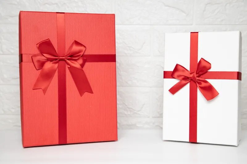 Person verpackt ein Geschenk zur Kommunion mit Geschenkpapier