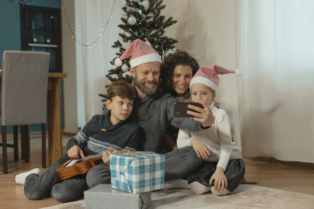 Familie schaut gemeinsam auf eine geteilte Weihnachtswunschliste Familie schaut gemeinsam auf eine geteilte Weihnachtswunschliste