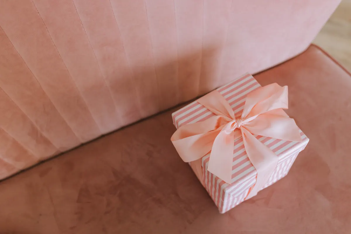 Eingepacktes Einzugsgeschenk mit Schleife auf einem Tisch Eingepacktes Einzugsgeschenk mit Schleife auf einem Tisch