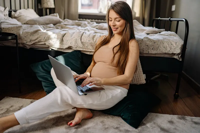 Werdende Eltern erstellen eine Wunschliste für ihre Babyparty am Laptop Werdende Eltern erstellen eine Wunschliste für ihre Babyparty am Laptop