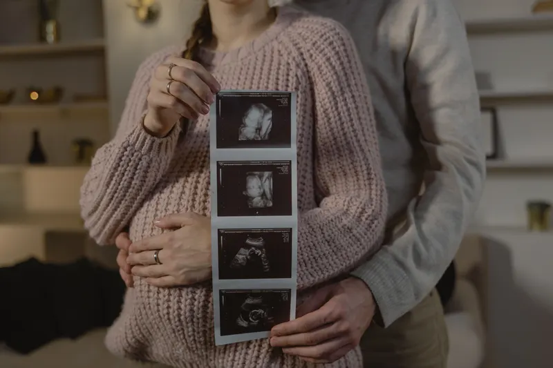Werdende Eltern planen die Baby-Erstausstattung am Laptop Werdende Eltern planen die Baby-Erstausstattung am Laptop