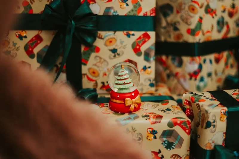 Person legt ein kleines Geschenk in einen Nikolausstiefel Person legt ein kleines Geschenk in einen Nikolausstiefel